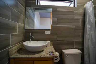 a bathroom with a sink and a toilet and a mirror at Nomada Monteverde in Monteverde Costa Rica