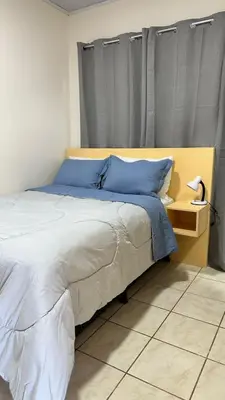 a bedroom with a large bed with blue pillows at Nomada Monteverde in Monteverde Costa Rica