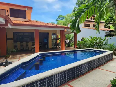 a swimming pool in front of a house at CASA DE PLAYA CON PISCINA EN PUNTA LEONA in Puntarenas