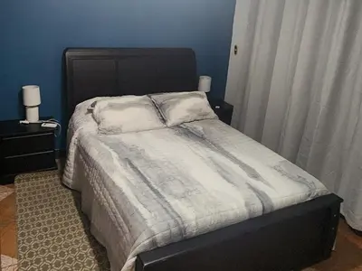 a bed in a bedroom with a blue wall at CASA DE PLAYA CON PISCINA EN PUNTA LEONA in Puntarenas