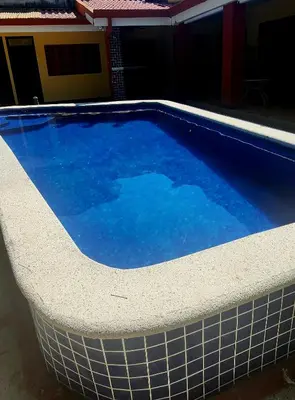 a large swimming pool with blue water at CASA DE PLAYA CON PISCINA EN PUNTA LEONA in Puntarenas
