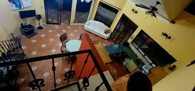 a dog is sitting in a living room with a snowboard at CASA DE PLAYA CON PISCINA EN PUNTA LEONA in Puntarenas