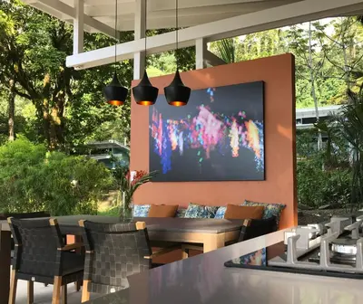 a restaurant with a table and chairs and a projection screen at Tree of Life Cabinas in Dominical