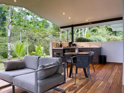 a kitchen and living room with a couch and a table at Tree of Life Cabinas in Dominical