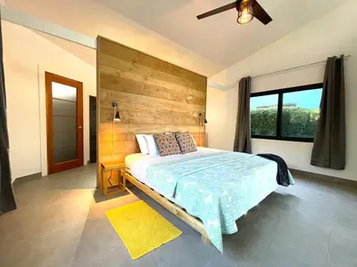 a bedroom with a large bed with a wooden headboard at Tree of Life Cabinas in Dominical