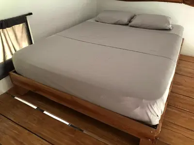 a bed with white sheets and pillows on it at The Elements Costa Rica Nature Lodges in Platanillo