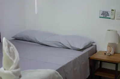 a bedroom with a bed and a table with a lamp at Leidy Mar Apartments in Santa Teresa Beach
