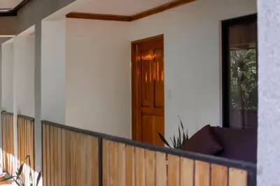 a house with a wooden door on a balcony at Leidy Mar Apartments in Santa Teresa Beach