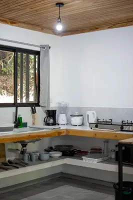 a kitchen with a counter with pots and pans at Leidy Mar Apartments in Santa Teresa Beach