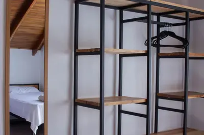 a room with a black bunk bed and wooden shelves at Leidy Mar Apartments in Santa Teresa Beach