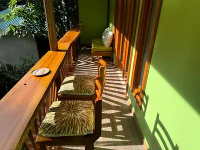 a row of benches sitting on a porch at Chilamate Room in Tortuguero