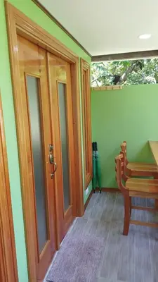 a room with a door and a bench and a table at Chilamate Room in Tortuguero