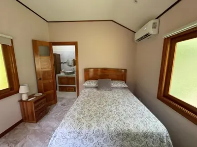 a small bedroom with a bed and a bathroom at Chilamate Room in Tortuguero