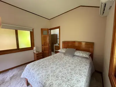 a bedroom with a bed and a window at Chilamate Room in Tortuguero