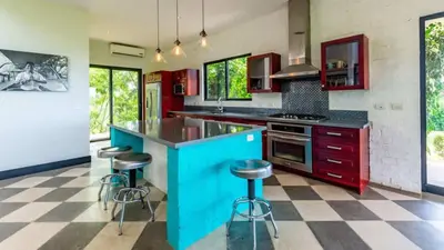 a kitchen with a blue island with bar stools at Nostalgic Retro Home on Luxurious Lot with a Private Infinity Pool and Ocean Views in Santa Cruz