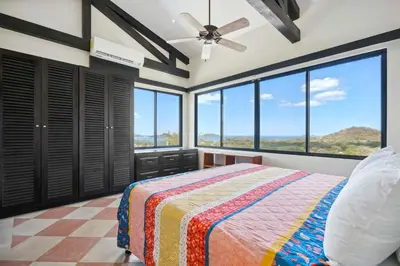 a bedroom with a bed and large windows at Nostalgic Retro Home on Luxurious Lot with a Private Infinity Pool and Ocean Views in Santa Cruz