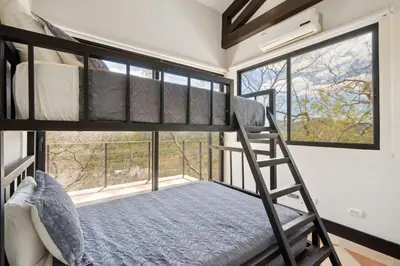 a bedroom with two bunk beds and a window at Nostalgic Retro Home on Luxurious Lot with a Private Infinity Pool and Ocean Views in Santa Cruz