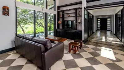 a living room with a leather couch and a checkered floor at Nostalgic Retro Home on Luxurious Lot with a Private Infinity Pool and Ocean Views in Santa Cruz