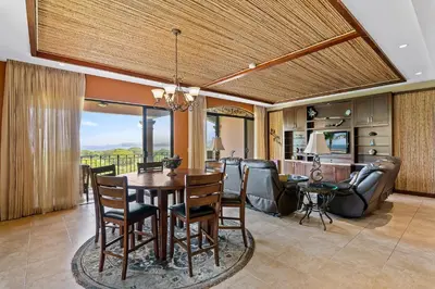 a dining room and living room with a table and chairs at Stunning Luxury Penthouse in Exclusive Beachfront Community with Resort-Style Amenities & Sweeping Views of the Ocean & Golf Course in Santa Cruz