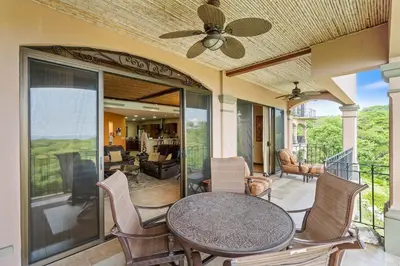 a patio with a table and chairs on a balcony at Stunning Luxury Penthouse in Exclusive Beachfront Community with Resort-Style Amenities & Sweeping Views of the Ocean & Golf Course in Santa Cruz