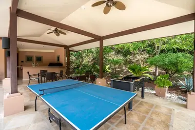 a ping pong table in the middle of a patio at Stunning Luxury Penthouse in Exclusive Beachfront Community with Resort-Style Amenities & Sweeping Views of the Ocean & Golf Course in Santa Cruz
