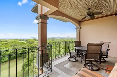a balcony with a table and chairs and a view at Stunning Luxury Penthouse in Exclusive Beachfront Community with Resort-Style Amenities & Sweeping Views of the Ocean & Golf Course in Santa Cruz