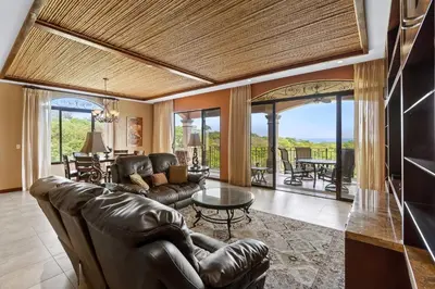 a living room with leather furniture and a table at Stunning Luxury Penthouse in Exclusive Beachfront Community with Resort-Style Amenities & Sweeping Views of the Ocean & Golf Course in Santa Cruz