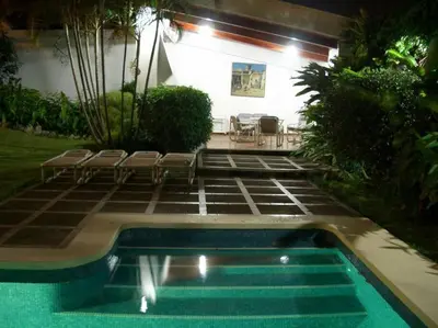 a swimming pool with chairs next to a house at Hermosa Habitación privada en la Sabana, San Jose in San José