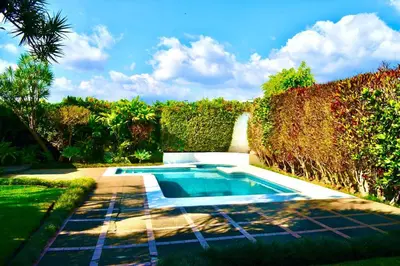 a swimming pool in the middle of a garden at Hermosa Habitación privada en la Sabana, San Jose in San José