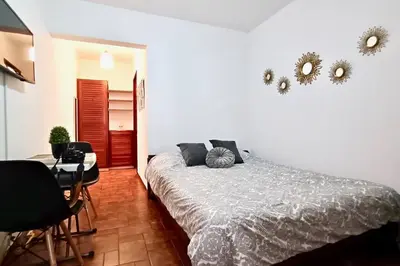 a bedroom with a bed and a table and chairs at Hermosa Habitación privada en la Sabana, San Jose in San José