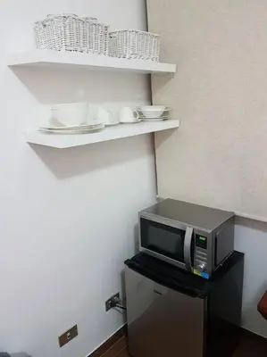 a microwave sitting on top of a refrigerator at Hermosa Habitación privada en la Sabana, San Jose in San José