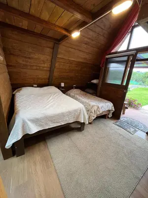 a bedroom with two beds in a room with a window at Chalets Vistas del Poas in Heredia