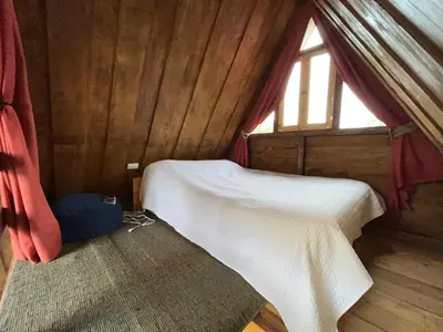 a bedroom with a bed and a window at Chalets Vistas del Poas in Heredia