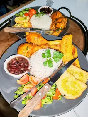 a plate of food with rice and vegetables on a table at Chalets Vistas del Poas in Heredia
