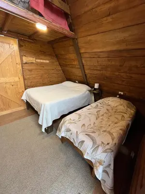 a room with two beds in a wooden cabin at Chalets Vistas del Poas in Heredia