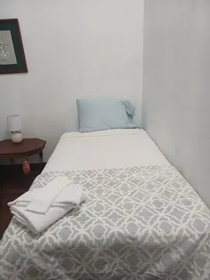 a bedroom with a bed with a white comforter at La posada de nana in Alajuela City