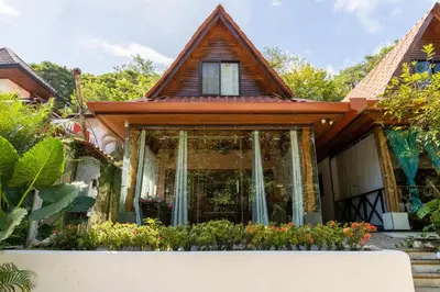 a house with a window and flowers in front of it at Cozy Beach Casita - 4 Min Walk to the Beach in Nosara
