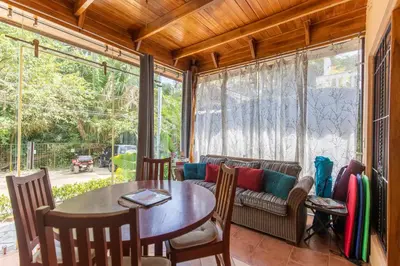 a screened in porch with a table and a couch at Cozy Beach Casita - 4 Min Walk to the Beach in Nosara