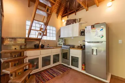 a kitchen with a stainless steel refrigerator and cabinets at Cozy Beach Casita - 4 Min Walk to the Beach in Nosara