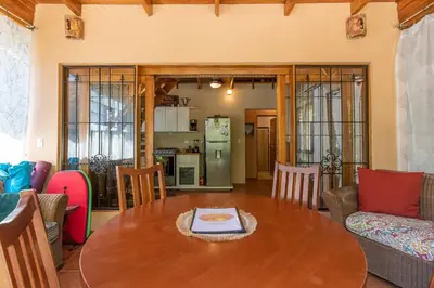 a living room with a table and a kitchen at Cozy Beach Casita - 4 Min Walk to the Beach in Nosara
