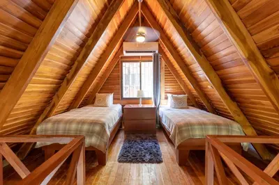 two beds in a attic bedroom with wooden ceilings at Cozy Beach Casita - 4 Min Walk to the Beach in Nosara
