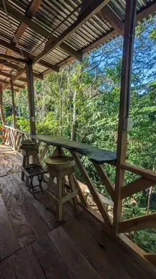 a wooden porch with a table and a bench on it at Landscape-Cabaña Summer-Full Equipada in La Cruz