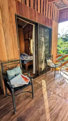 a room with a chair and a bed and a window at Landscape-Cabaña Summer-Full Equipada in La Cruz