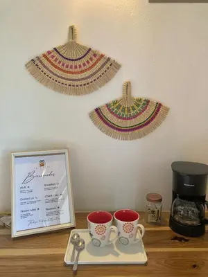 a table with two cups and a plate with a coffee maker at Casa Yami Lodge in Fortuna