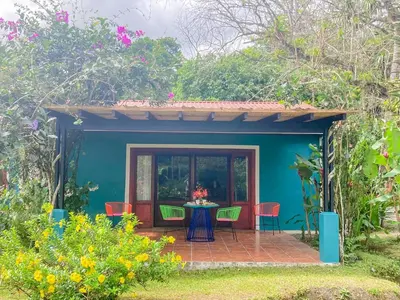 a patio with a table and chairs in a garden at Casa Yami Lodge in Fortuna