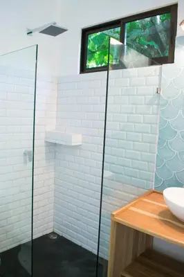 a bathroom with a glass shower and a sink at Casa Yami Lodge in Fortuna