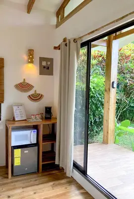 a room with a desk and a sliding glass door at Casa Yami Lodge in Fortuna