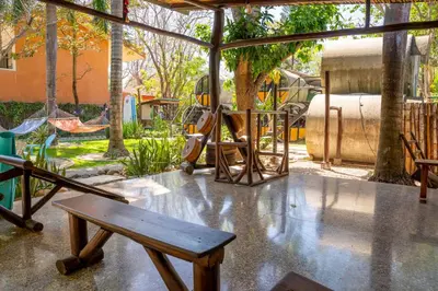 a park with a playground with a bench and swings at Pipe House Playa Grande in Playa Grande
