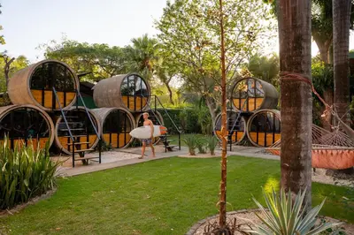 a woman standing in front of a pod house at Pipe House Playa Grande in Playa Grande