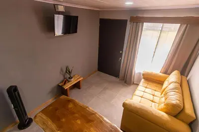 a living room with a couch and a television at 1968house in Monteverde Costa Rica